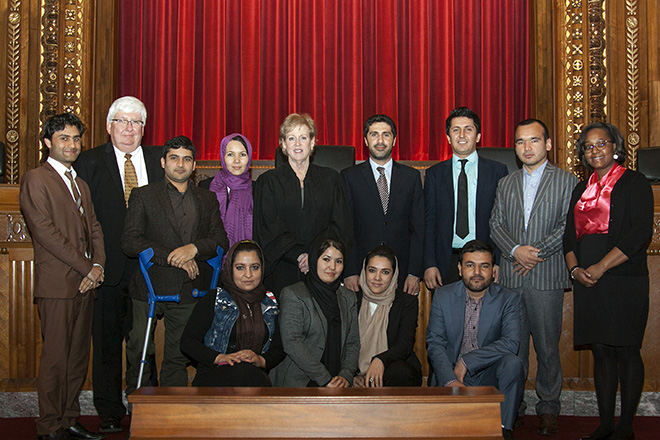 Image of Ohio Supreme Court Chief Justice Maureen O'Connor posing for a picture in the courtroom of the Thomas J. Moyer Ohio Judicial Center with a visiting judge and attorneys from Afghanistan