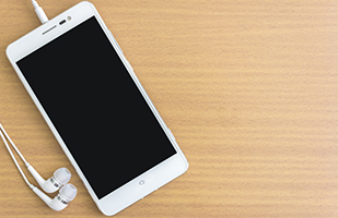 Image of a smartphone with ear buds lying on a table (THINKSTOCK) Image of a smartphone with ear buds lying on a table (THINKSTOCK)