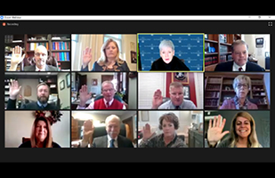 Image of 12 men and women, some with hands raised, participating in a virtual conference