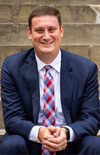 Image of a man wearing a suit sitting on concrete steps