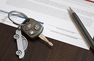Image of a silver car-shaped keychain holding a single car key, sitting on top of a document along with an ink pen (Thinkstock) Image of a silver car-shaped keychain holding a single car key, sitting on top of a document along with an ink pen (Thinkstock)
