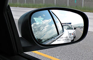 Image of a police cruiser as seen in a car's side mirror (Photo Credit: Derek Miller/Thinkstock) Image of a police cruiser as seen in a car's side mirror (Photo Credit: Derek Miller/Thinkstock)