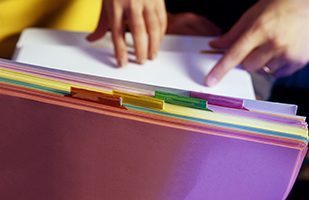 Image of someone thumbing through a stack of file folders (Thinkstock)