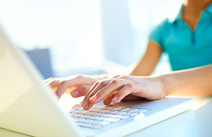 Image of a young person working on a laptop computer