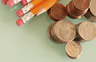 Image of a bunch of yellow pencils laying next to stacks of pennies, nickels, dimes, and quarters