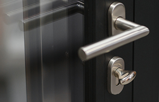 Image of a closed door with a chrome handle and lock.