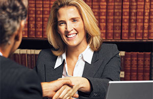 Image of a woman in a business suit shaking hands with a man in a business suit