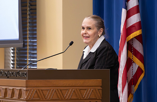 Images of retired Ohio Supreme Court Justice Evelyn Lundberg Stratton speaking from behind a wooden podium.