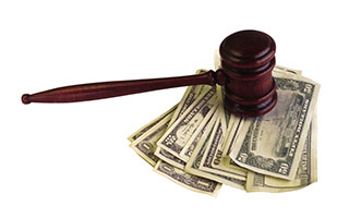 Image of a pile of money underneath a judges' gavel (Stockbyte/Thinkstock)