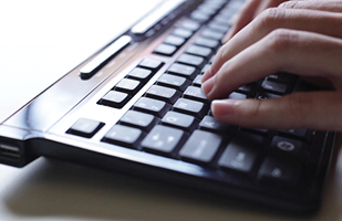 Image of a person typing on a computer keyboard