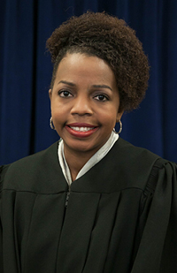 Image is a head shot photo of Judge Carla Baldwin in her judicial robe