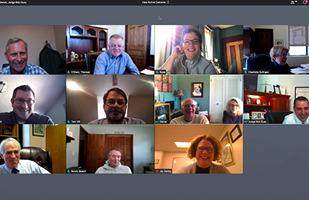 Image of a computer screen showing 11 people in separate screens participating in a video meeting