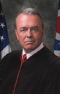 Image is of a headshot of Judge Stephen Powell in his black judicial robe