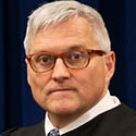 Image is a headshot of Judge Ronald C Lewis in his black judicial robe