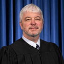 Image is a headshot of Justice Michael P. Donnelly in his black judicial robe
