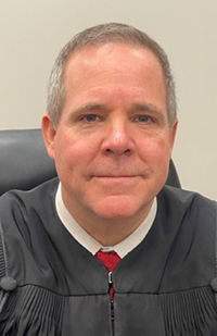 Image is a headshot of Judge-designate David McNamee in his black judicial robe