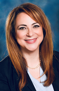 Image of a woman with long reddish-brown hair, wearing a blue suit.