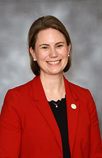 Image of a woman wearing a black top and red blazer