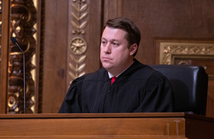 Image of a male judge wearing a black judicial robe