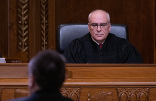 Image of Judge Mark Miller in black judicial robe on a bench.