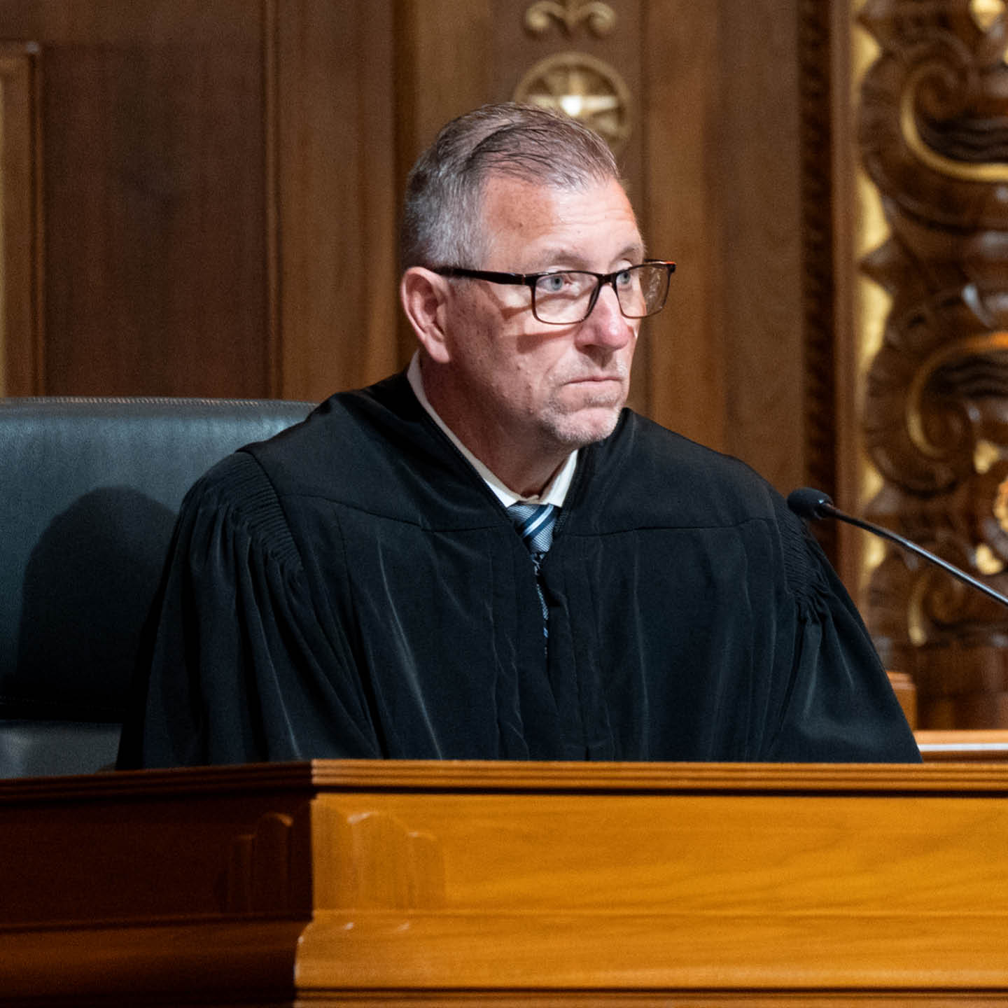 Male judge wearing a black judicial robe.