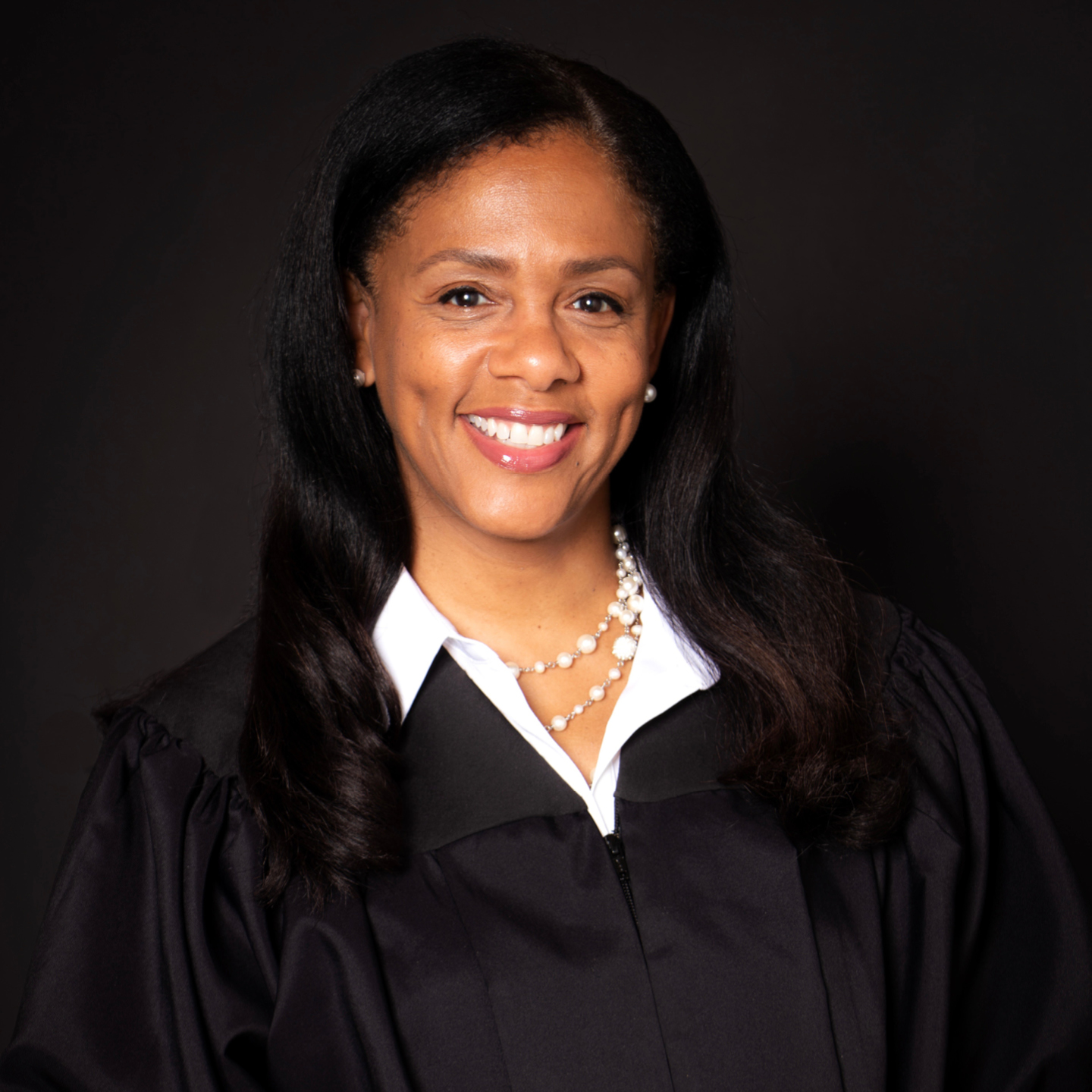 A judge in a black robe smiling