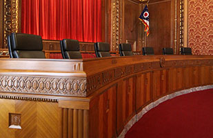 Image of an empty Supreme Court of Ohio bench in the courtroom of the Thomas J. Moyer Ohio Judicial Center