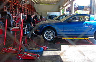 Image of a car on a lift in an autorepair shop (Photo by Robert Couse-Baker/CC BY 2.0)