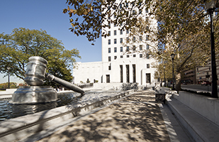 Image of a giant steel gavel sitting in a reflecting pool in the south plaza of the Thomas J. Moyer Ohio Judicial Center