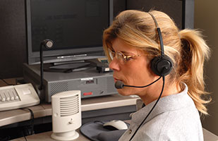 Image of a female 911 operator wearing a telephone headset (David Smith/Thinkstock)