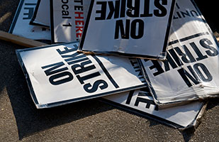 Image of a pile of signs that say 'On Strike' (John Kershner/Thinkstock)