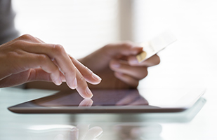 Image of a person making an online purchase using a credit card on a tablet (LDProd/Thinkstock)