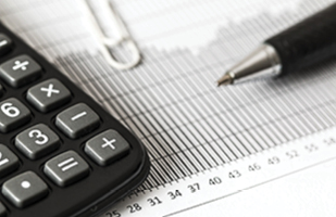 Image of a calculator next to a pen on top of a paper