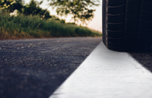 Image of a vehicle tire on a white line on a road