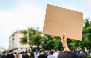 People holding up signs in protest outdoors.