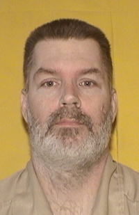 Image of a bearded prison inmate wearing a beige shirt