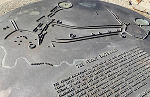 Image of a bronze plate embossed with words and a map
