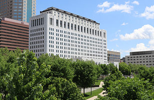 Image of the Thomas J. Moyer Ohio Judicial Center as seen through the trees along the Scioto River