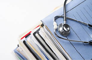 Image showing a doctor's stethoscope sitting on top of a stack of folders.