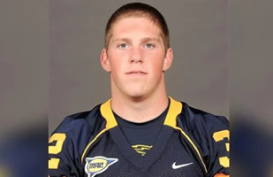 Image of a young man wearing a blue and gold football jersey.