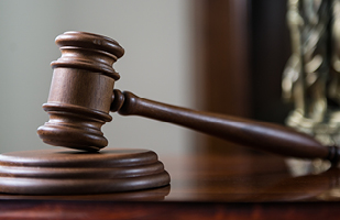 Image of a gavel on a judge's bench.