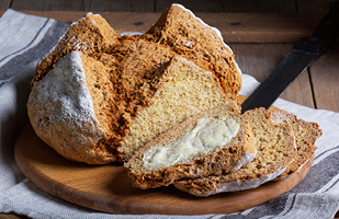 Image of a cut-up loaf of soda brean on a wooden platter.
