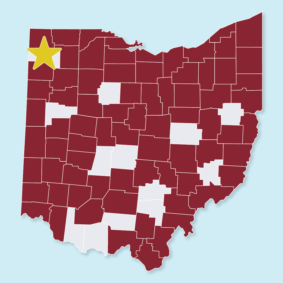 County map of Ohio with most counties colored red, and others colored grey. A gold star appears over Defiance County.