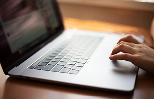 A person scrolling on a laptop using the trackpad