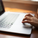 A person scrolling on a laptop.