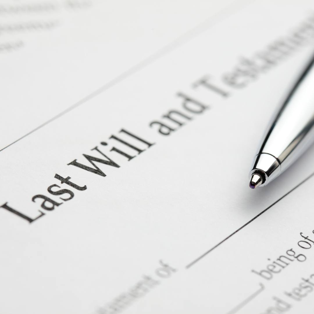 A document with the words 'Last Will and Testament' at the top and a pen resting on it.