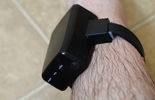 A black ankle monitor attached to a leg.