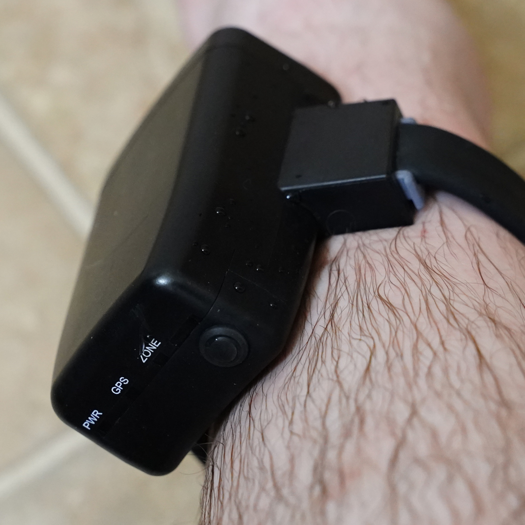 A black ankle monitor attached to a leg.