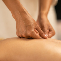 Two fists pressing down on the bare back of a person.