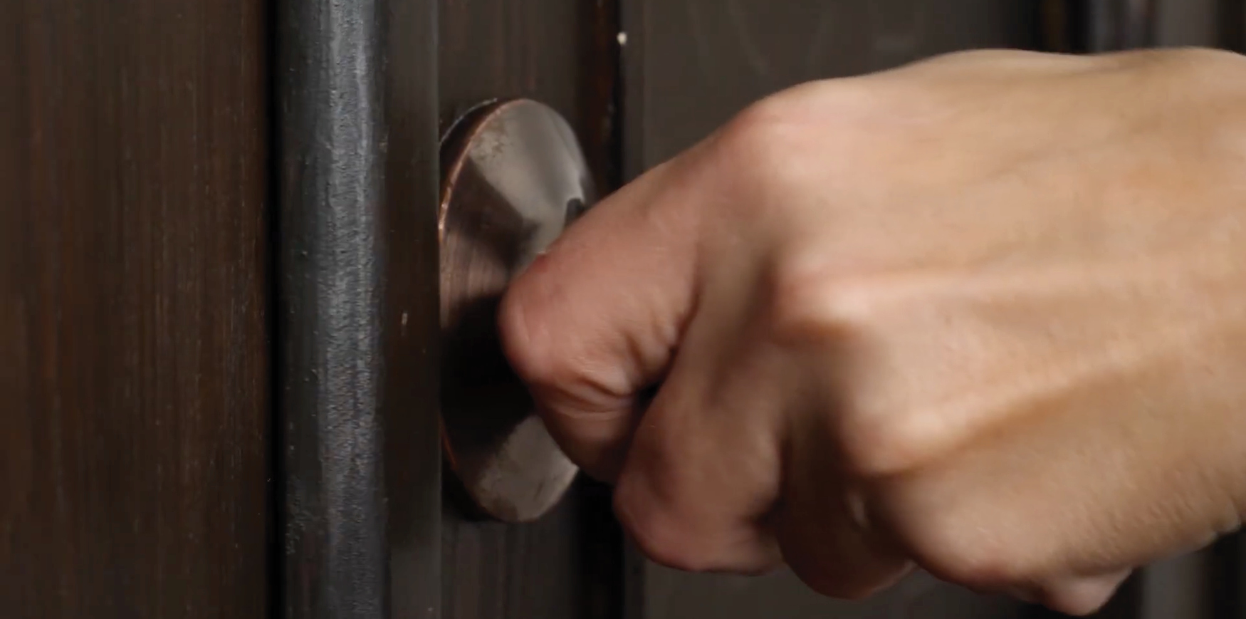 A hand on a door knob.